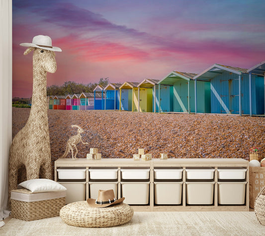 A beautiful row of colorful beach huts on a shingle beach.


