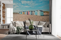 Beach Huts on the Shore Wall Mural behind a modern living room with layered seating, GD8871