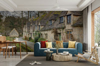 A narrow, wet road leads past the buildings.

