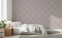 Bedroom scene where Bloomscape Beige Wallpaper sits behind a neatly arranged bed