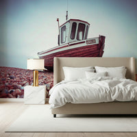 Ocean vessel Boat Resting on Pebbled Strand serene cloudy sky wallpaper print.