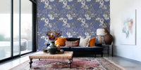 Muted blue wallpaper with hand-drawn flowers and layered leafy branches