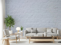 Living room with Brick Decor Wall Mural behind a beige sofa and light wood table