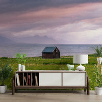 Lush green meadow meeting the tranquil sea under soft skies

