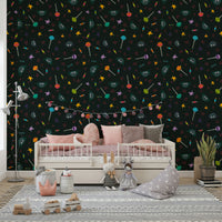 An angled shot of a wall with dark, whimsical wallpaper

