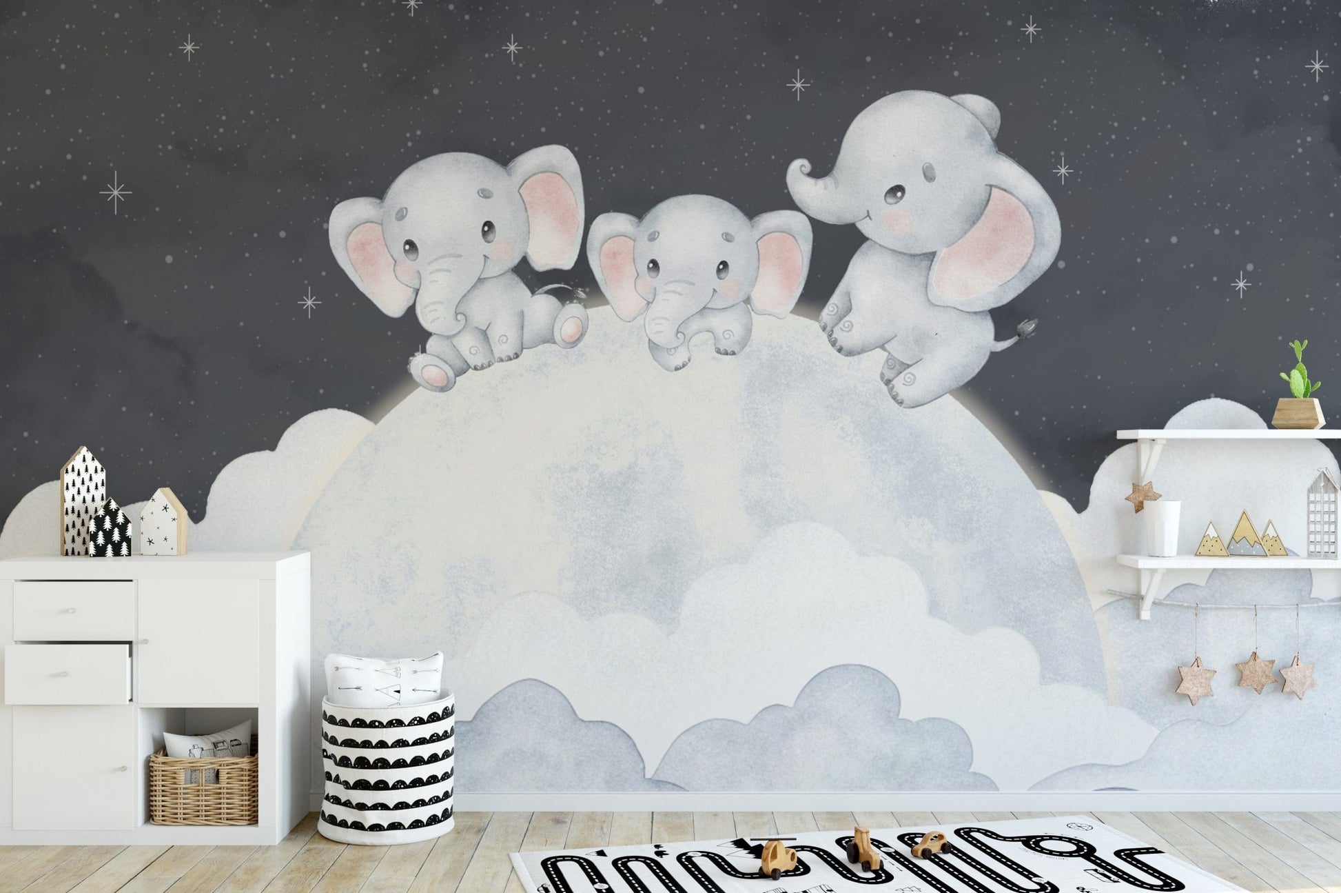 Baby elephants sitting on moon mural
