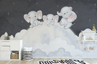 Baby elephants sitting on moon mural
