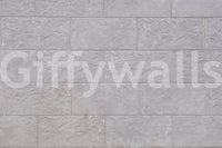 Luxurious feel of the Elegant Stone Blocks peel and stick mural behind a fireplace.