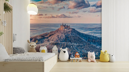 A medieval castle sits on a snowy mountaintop.

