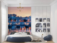 Sunset cityscape wall mural with warm reflections on the water