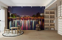 The water in the canal is calm and reflects the lights.


