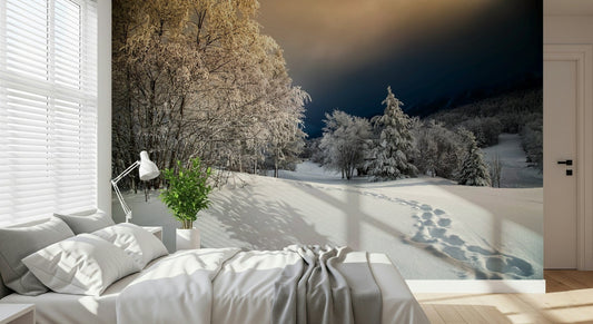 Snowy landscape wall mural with golden sky displayed in a warm bedroom.