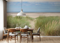 A window-side dining corner framed with Grassland by the Sea Wall Mural and open dunes