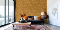 Window-side lounge framed by Homeland Floral Golden Wallpaper and warm accents