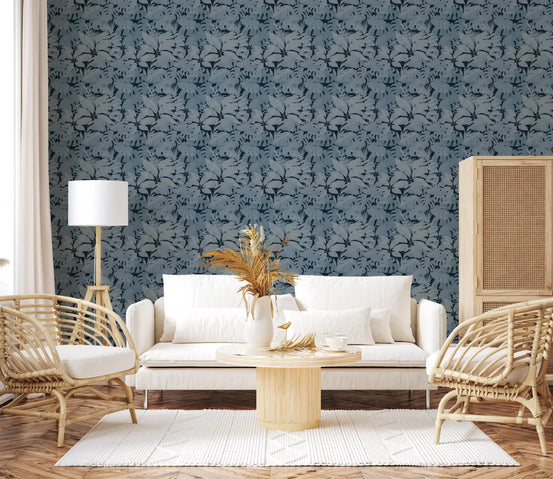 Indigo Botanical Monstera Leaves Wallpaper behind a white sofa in a bright lounge, GD8948
