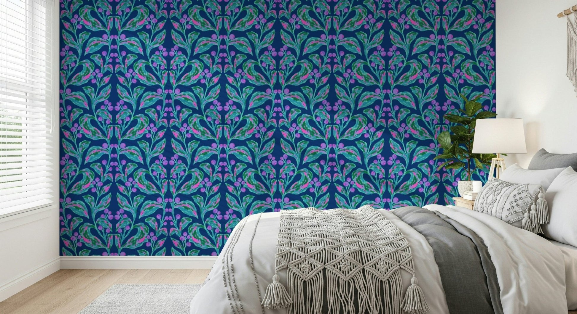 Indigo electric leaves wallpaper behind a neutral grey sofa in a lounge.