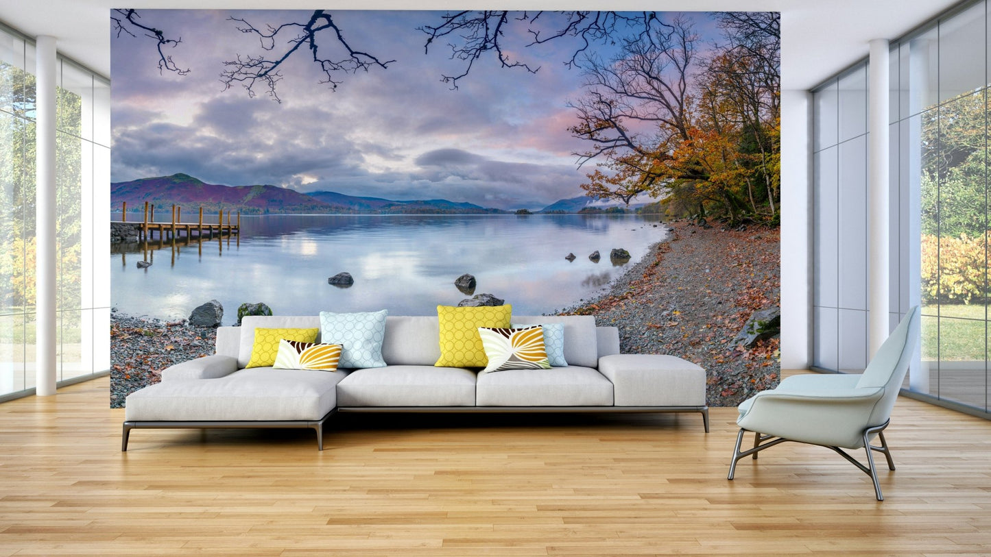 The image shows a calm lake surrounded by hills and mountains.

