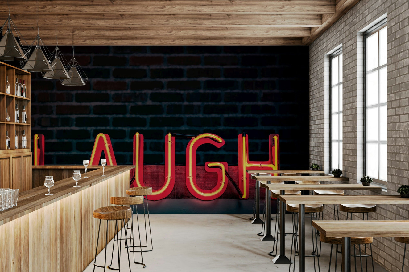 A beautiful neon glow wallpaper mural with a 'Laugh' script and bold, vibrant colors.