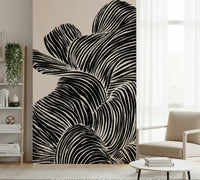 Compact lounge corner framed by Linear wall mural in matte black curved forms