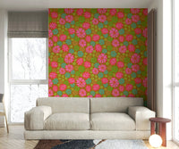 The mural is installed in a cheerful living room behind a simple, light-colored sofa.

