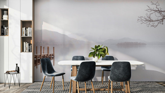 A beautiful serene lake with misty mountains in the background.

