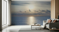 Peaceful seaside wallpaper showcasing a glowing sky and distant clouds.