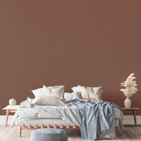 The mural is installed in a rustic living room behind a simple, light-colored sofa.

