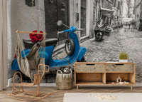 The scooter is parked on a cobblestone street.

