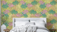 Monstera leaves in pastel colors on avocado wall covering

