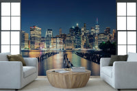 Night city skyline wall mural with glowing office buildings and water reflections.
