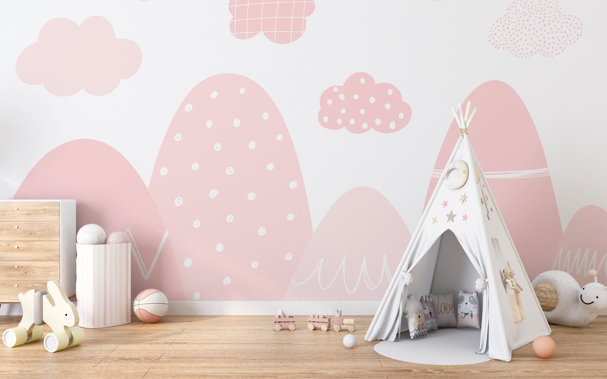 Pink nursery wallpaper with white mountains and clouds.