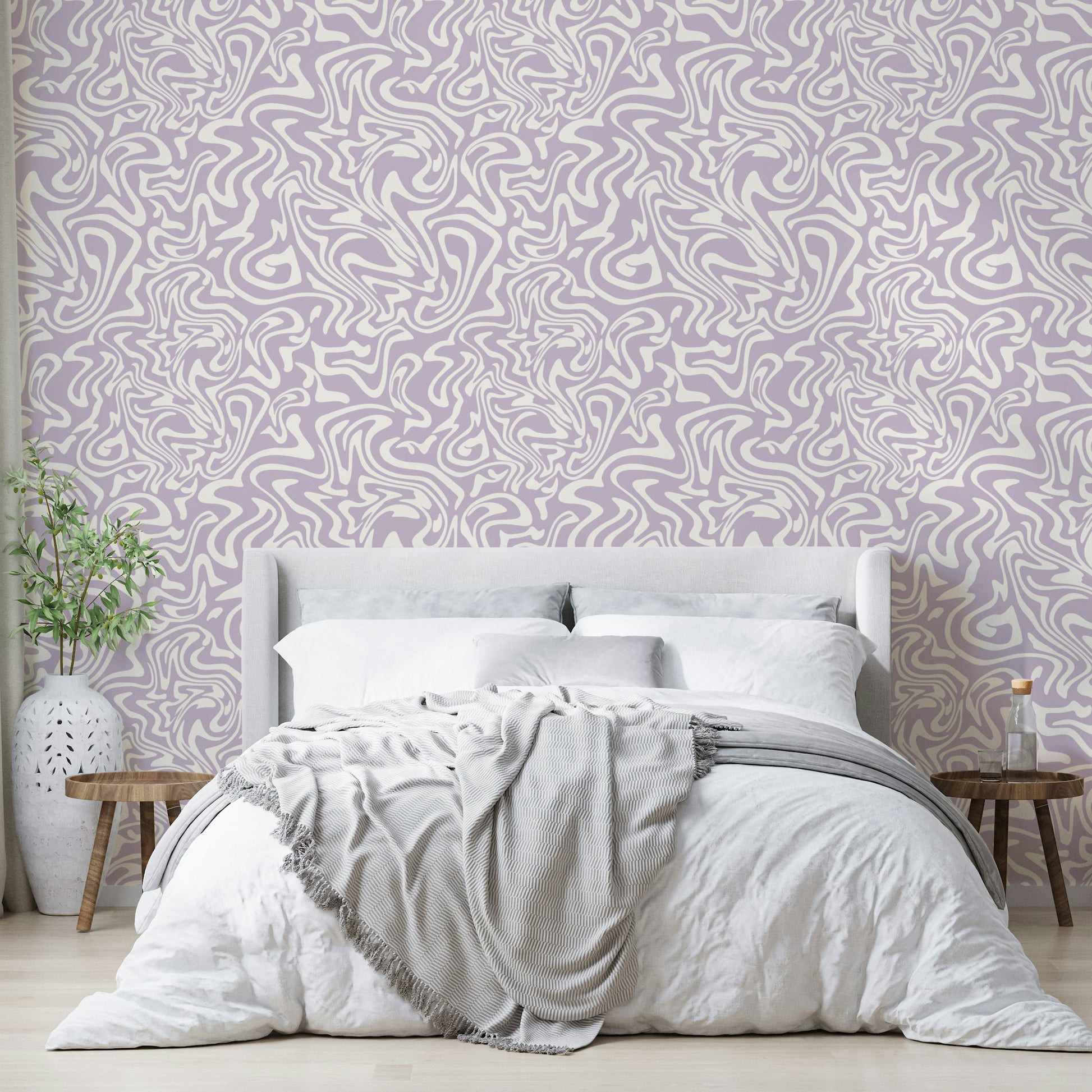 The pink swirls wallpaper applied to a wall behind a bed.

