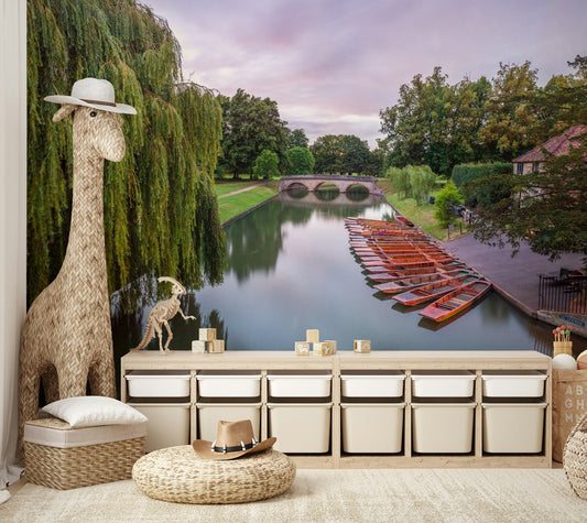 A peaceful wall mural with a view of a boat on a river.

