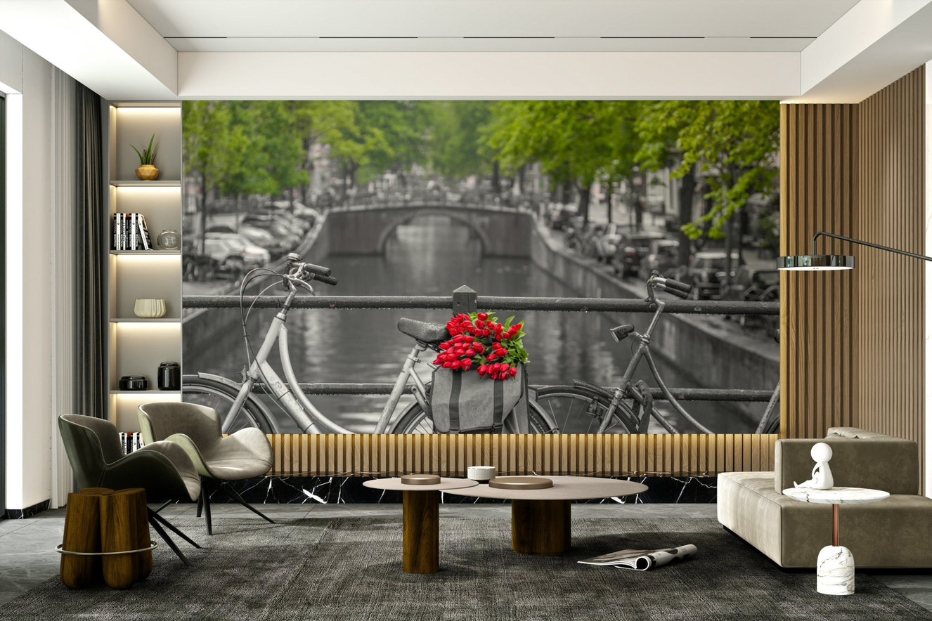 A beautiful bicycle with a bouquet of red tulips on an Amsterdam canal bridge.

