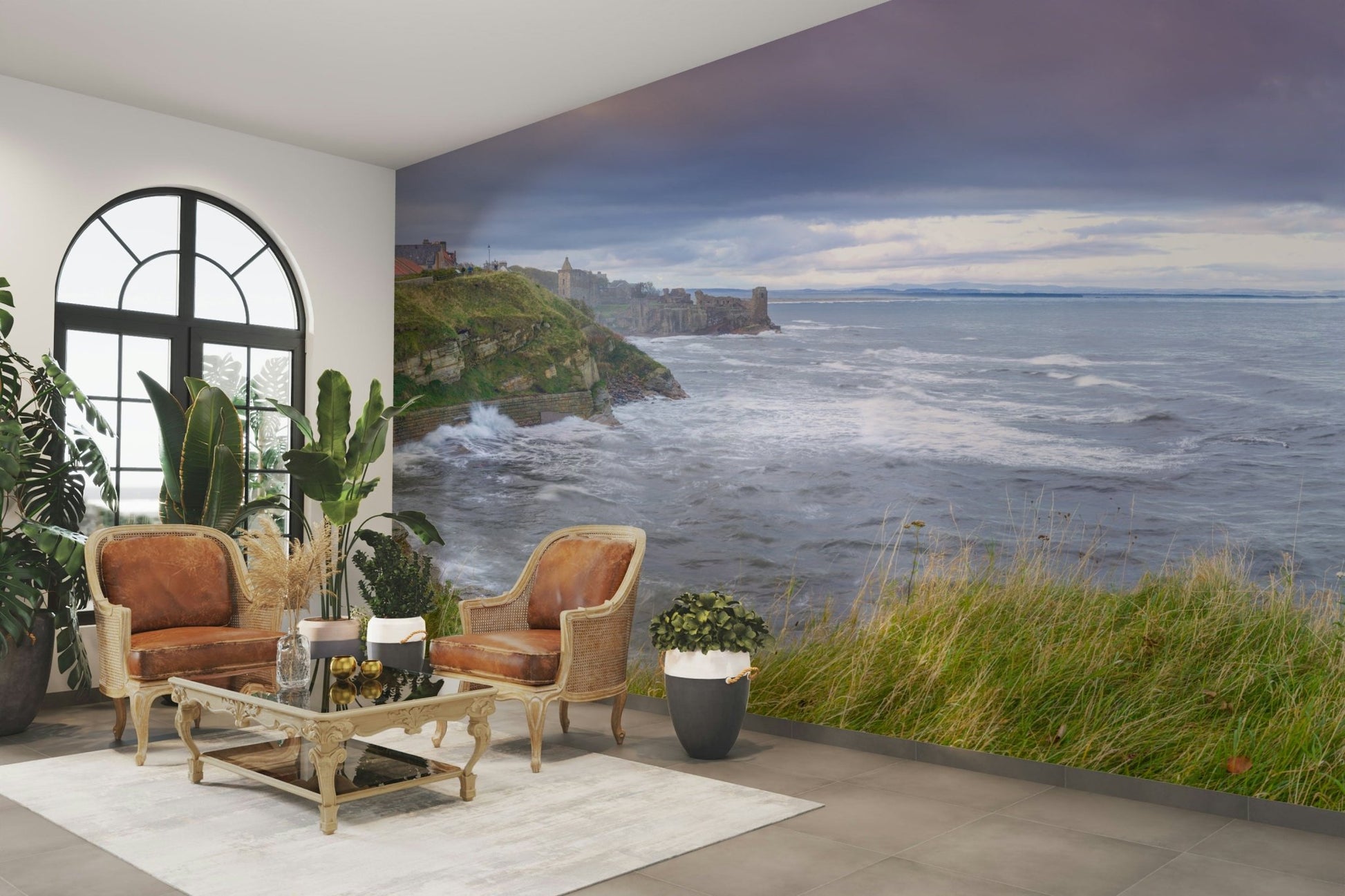 The foreground has green grass and a path along a fence.

