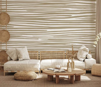 Sand Stripe Flow Wall Mural behind a curved sofa in a cozy neutral living room