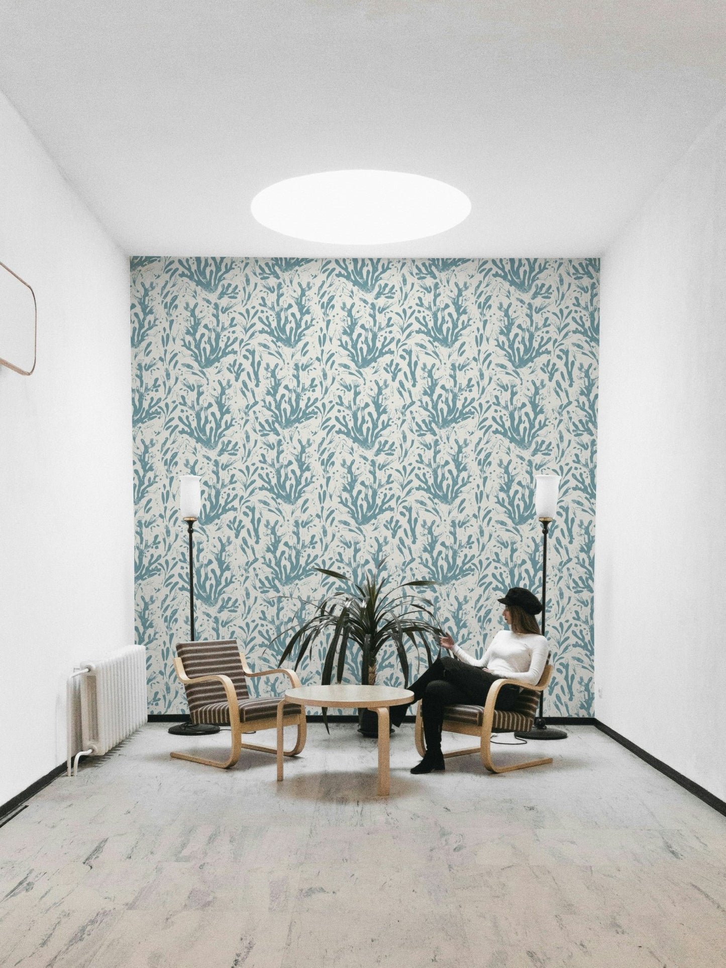 An installation view of the wallpaper being hung on a wall.


