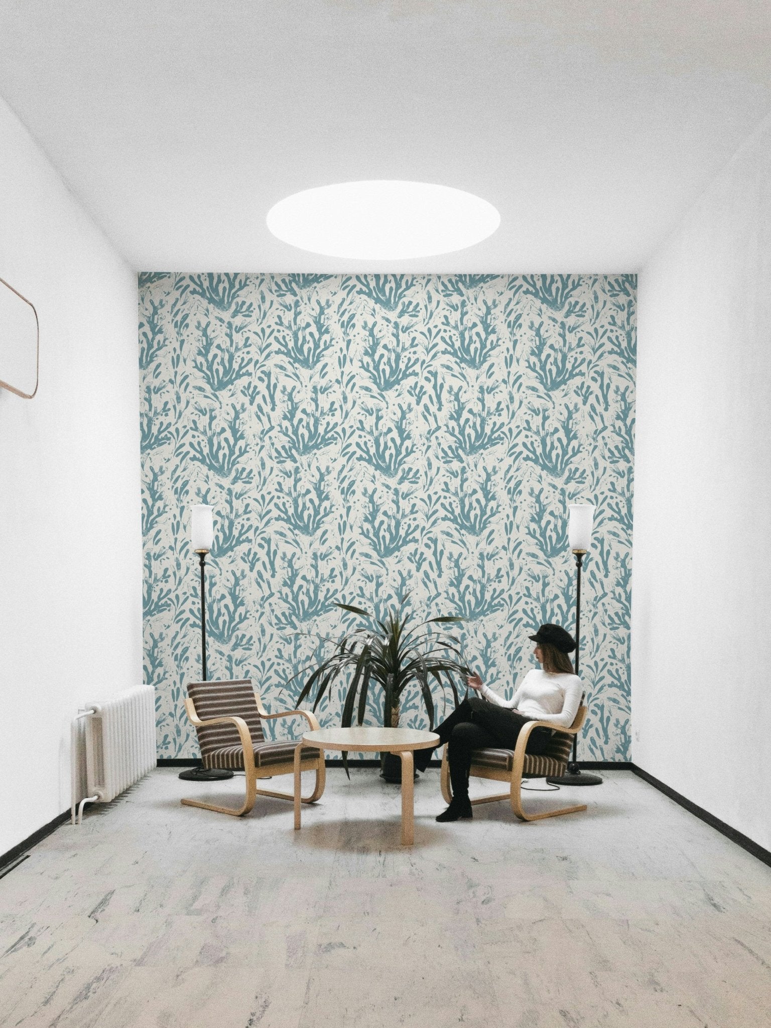 An installation view of the wallpaper being hung on a wall.

