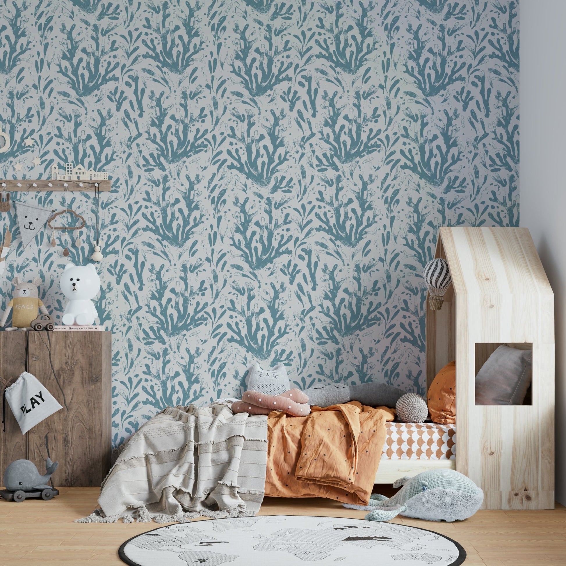 A child's bedroom wall covered in a sea life wallpaper.

