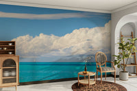 Three small sailboats are visible on the horizon.

