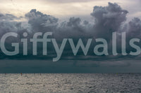 Colorful sails dot the far water below gray cloud in this Seaside #8 wall mural GD4784
