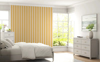 Bedroom corner with Sunny Stripes Wallpaper in soft yellow striped tones