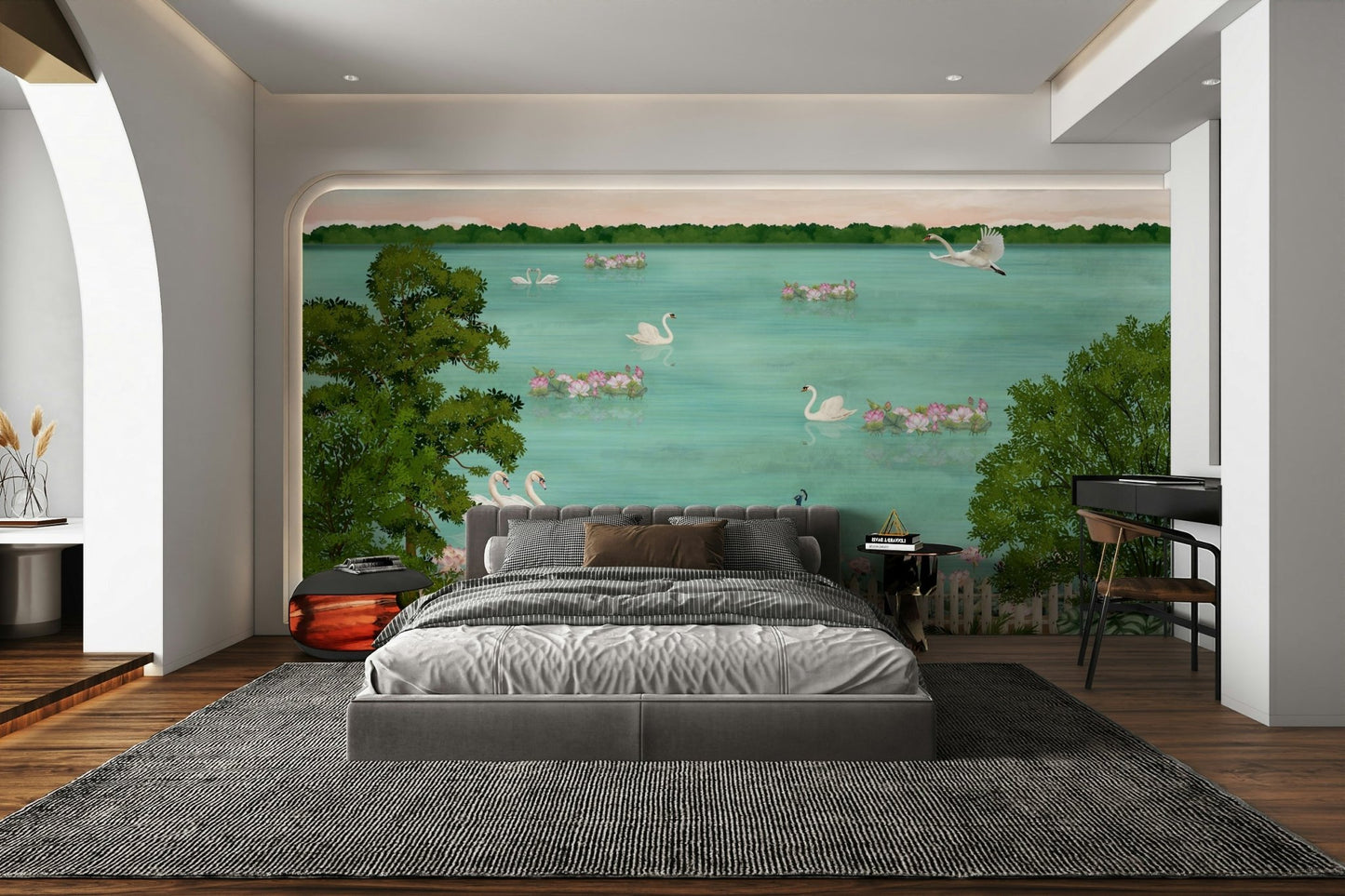 The water has a soft reflection of the trees and swans.
