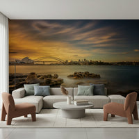 A serene cityscape wall mural in warm, orange and purple tones.