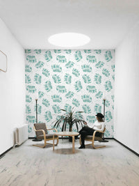 Mural wallpaper featuring tossed palm leaves in aqua

