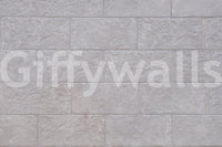 Luxurious feel of the Elegant Stone Blocks peel and stick mural behind a fireplace.