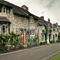 Historic village wall mural with grey stone walls and a rustic red entrance.