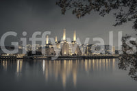 Grey cityscape mural with four illuminated chimneys above a waterfront building., GD10468