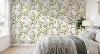 Calm bed space framed by whimsical rococo vineyard wallpaper with leafy branches